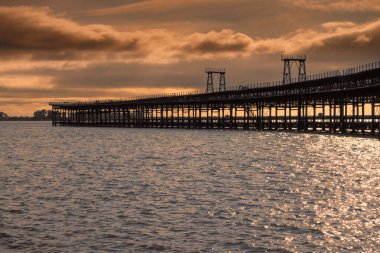 Pier of the Rio Tinto Company at sunset (Huelva, Spain). Rio Tinto mineral loading pier declared an Asset of Cultural Interest. Pier at sea.