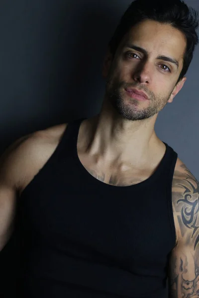 ポルノのAハンサムな筋肉男で黒上ポーズ上の灰色の背景 — ストック写真