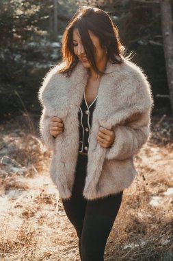 Şık kış çekimleri kürk ceketli güzel bir kadın ışıldıyor ve kendine güvenen bir duruşu var.