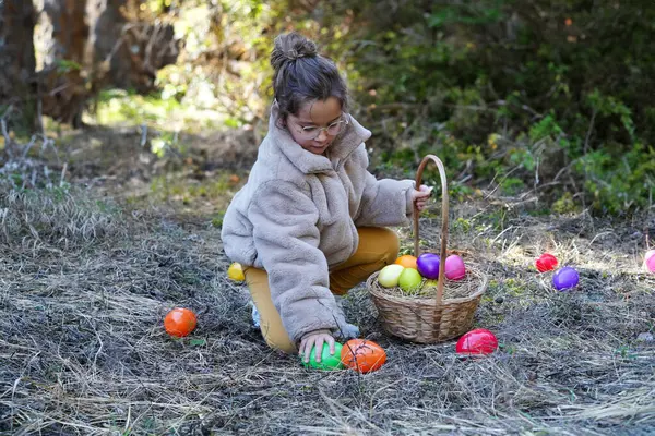 可爱的小女孩在户外采摘复活节彩蛋 免版税图库图片