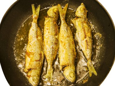 Beyaz arka planda izole edilmiş kızartma tavasında kızarmış balık.