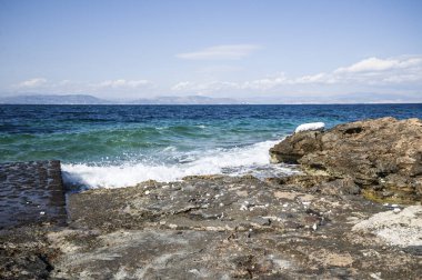 Yazın güzel manzarası, taştan bir kıyısı olan mavi deniz. Aegina Adası, Yunanistan