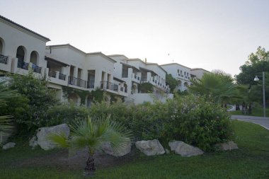 Kyllini, Peloponnese, Yunanistan - 16 Haziran 2024: Yunanistan 'daki Grecotel Lüks Oteli. Olympia Riviera, bungalov binaları ve turist taşıyan elektrikli bir araba.