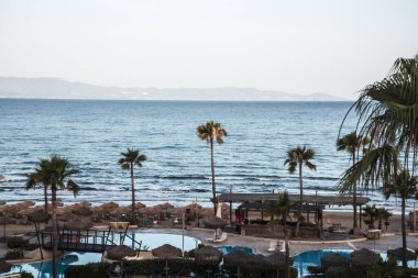 Kyllini, Peloponnese, Yunanistan - 16 Haziran 2024: Yunanistan 'daki Grecotel Lüks Oteli. Yunanistan 'daki Grecotel Lüks Oteli' nin Olympia Riviera Oteli 'nin havuzunun yanındaki plaj sandalyesi ve şemsiyesi