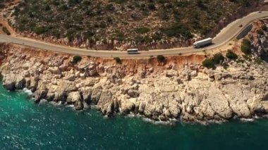 Türkiye 'de Akdeniz kıyısında bir otoyol. Sahil yolunun havadan görüntüsü. Otobüs ve kamyon kıyı boyunca gidiyor.