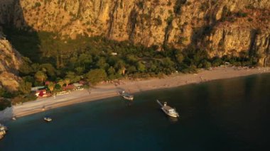 Türkiye 'nin Oludeniz kentindeki Kelebek Vadisi' nin hava gün batımı manzarası. Yüksek uçurumlar arasında Akdeniz ve sahil 