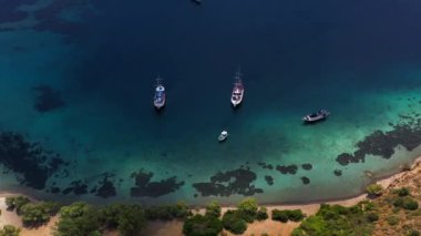 Yelkenli tekne, yat, turkuaz berrak su ve kıyı şeridi olan Akdeniz manzarası