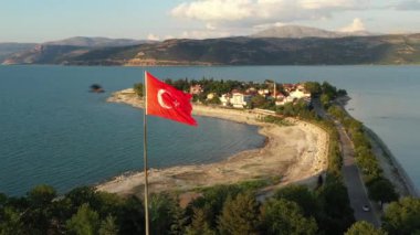 Türkiye bayrağı, Egirdir Gölü ve dağları ile birlikte Türk doğasının güzel manzarası arasında rüzgarda dalgalanıyor.
