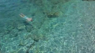 Adam denizde suyun altında yüzüyor. Genç adam Akdeniz sahillerinde dalıyor ve yüzüyor..