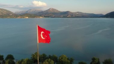 Türkiye bayrağı, Egirdir Gölü ve dağları ile birlikte Türk doğasının güzel manzarası arasında rüzgarda dalgalanıyor.