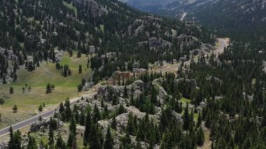 Dağlar, kayalar ve orman arasındaki otoyol. Dağ yolunun vahşi doğadaki gerçek manzarası. 