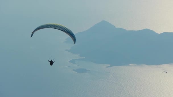 唯一のパラグライダーは トルコのOludenizの海と島の海岸風景の上を飛んでいます — ストック動画