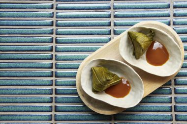 Tatlı bir pasta ya da muz yaprağına sarılmış yapışkan pirinç şekeri. Geleneksel bir Malezya, Tayland, Vietnam ya da Japon tatlısı..