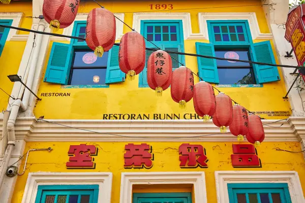 stock image Kuala Lumpur, Malaysia - 22 June 2023. A colorful blue and yellow chinese restaurant building decorated with traditional red lanterns.