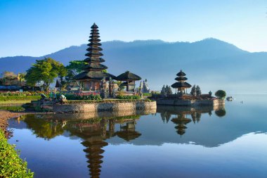 Göldeki Ulun Danu Beratan Tapınağı 'nın sabah manzarası. Bali 'nin en ikonik ve en ünlü tapınağı dağlarla çevrili.