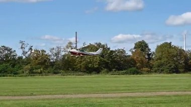 Leverkusen, Almanya - 26 Ağustos 2023: Uçan Cessna uçağı Flugfest Leverkusen 'de canlı ağaçların üzerinde süzülüyor, resimli bir ortamda havacılığın heyecanını yakalıyor.