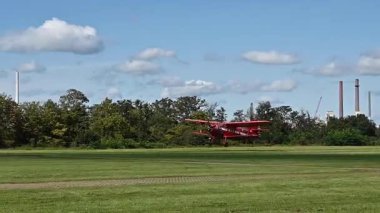 Leverkusen, Almanya - 26 Ağustos 2023: Flugfest Leverkusen 'de yemyeşil alanda kırmızı renkli klasik çift kanatlı uçak, havacılığın heyecanını yakalıyor. Yüksek kaliteli FullHD görüntüler