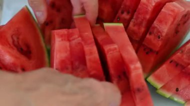 Taze olgun karpuz Dilimlenmiş Yakın çekim videosu. Yakından bakınca olgun kırmızı bir karpuzun dilimlendiğini görüyoruz. Sulu dokusu ve görünür tohumları onu yazın mükemmel bir temsili yapıyor.