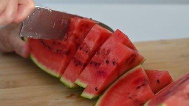 Taze olgun karpuz Dilimlenmiş Yakın çekim videosu. Yakından bakınca olgun kırmızı bir karpuzun dilimlendiğini görüyoruz. Sulu dokusu ve görünür tohumları onu yazın mükemmel bir temsili yapıyor.