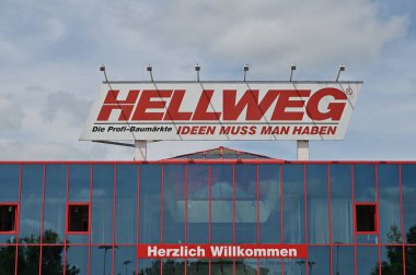 Selm, Almanya - 11 Haziran 2025: Selm 'deki Hellweg hırdavat mağazasında çarpıcı kırmızı tabela ve modern cam mimarisi, davetkar bir alışveriş deneyimi yarattı