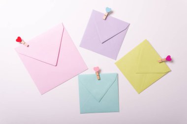 Sevgililer günü zarfı doğum günü partisi davetiyeleri sarı yeşil üst görünüm beyaz arka plan farklı boyutta pin