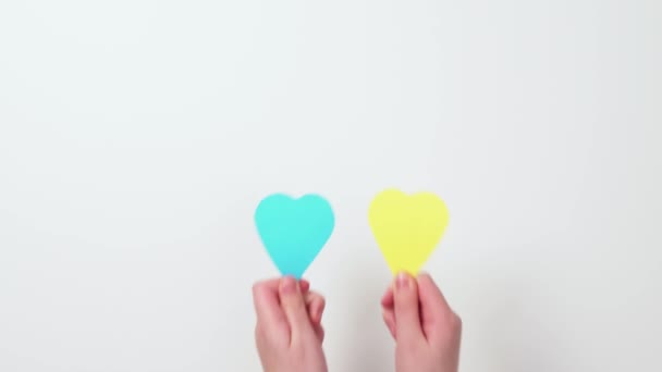 Παιδικά Χέρια Βάζοντας Χρωματιστές Χάρτινες Καρδιές Λευκό Φόντο Ουκρανική Κίτρινη — Αρχείο Βίντεο