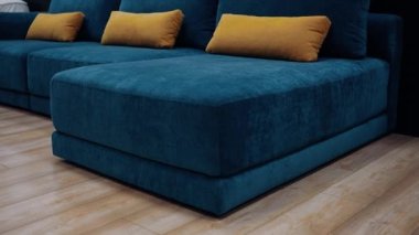 Dark blue smooth sofa model with long yellow cushions. 4k video.