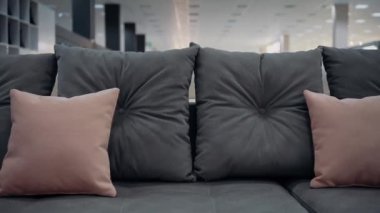 Close-up shot of a dark gray couch with red decorative pillows. 4k video.