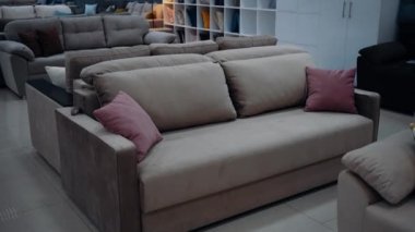 Brown sofa with red cushions set up in a furniture store. 4k video
