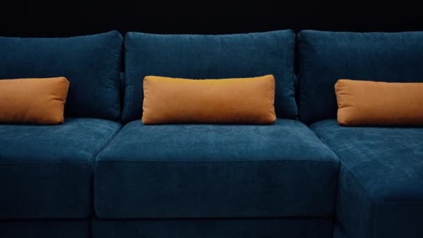 遅いショットでオフィスに向かって暗い青のソファとともに3つの長い黄色の枕 動画クリップ
