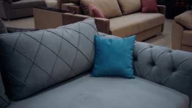 Küçük mavi bir yastığa, rahat gri bir kanepede yakınlaştır. 4k video