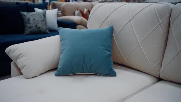 白いソファに座って柔らかい青い枕にズームフレーム ミニマルなコンセプト 4Kビデオ ロイヤリティフリーのストック動画