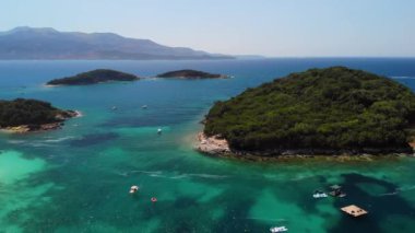 Arnavutluk 'un Ksamil Adaları' ndaki turkuaz suyu bulunan tropik plajların havadan görünüşü. Egzotik cennet kıyıları. Yunanistan yakınlarında temiz suyla kıyıya vurmuş. Yaz tatilinde. İyon Denizi üzerindeki Panorama Balkan kıyıları