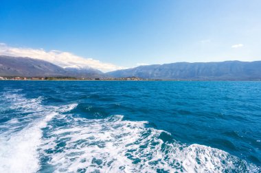 Arnavutluk 'un Vlora tatil beldesinin plajı. Yaz güneşli bir gün. Şehir ve Adriyatik Denizi manzarası.