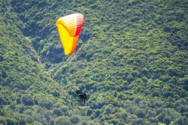 Yaz günü içinde Dağların üzerinden uçan Yamaçparaşütü.