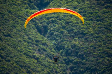 Yaz günü içinde Dağların üzerinden uçan Yamaçparaşütü.
