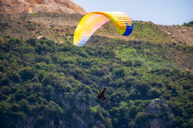 Yaz günü içinde Dağların üzerinden uçan Yamaçparaşütü.