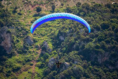 Yaz günü içinde Dağların üzerinden uçan Yamaçparaşütü.