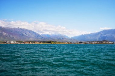 Arnavutluk 'un Vlora tatil beldesinin plajı. Yaz güneşli bir gün. Şehir ve Adriyatik Denizi manzarası.