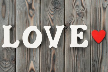 Beyaz plastik ya da ahşap harflerin kapatılması aşk kelimesini oluşturur, kelimenin yanında kırmızı kağıt kalp. Sevgililer Günü 'nden önce sevgi ve ilgi, 8 Mart, doğum günü ya da anneler günü. Üst görünüm, düz görünüm, kopyalama alanı