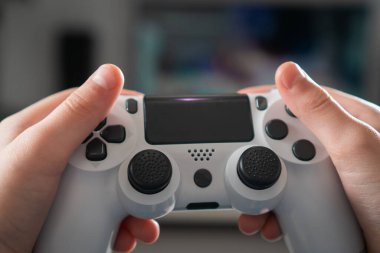 Erkek eller modifiye edilmiş plastik joystick 'i yakın plan, seçici odaklanma. Kişi video oyunları oynar. Kablosuz oyun konsolunu tutun. Kontrol düğmelerine parmaklarınla bas. Modern teknoloji ve oyun.