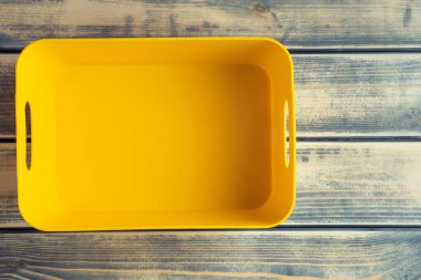 Sarı boş plastik konteynır, tahta masa arkasındaki kutu. Sürdürülebilir kalkınma, geri dönüşüm ve sıralama. Sürdürülebilir yaşam, çevre dostu yaşam ve geri dönüşüm sorumluluğu. Boşluğu kopyala