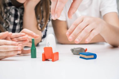 Masa oyunu oynayan bir grup çocuğun kesilmiş fotoğrafı evdeki beyaz masada aniden beliriyor, küçük bir figür seçiyorlar: yeşil şişe, kırmızı koltuk, mavi kitap, gri fare, beyaz hayalet.