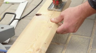 Tanımlanamayan bir adamın elektrikli testereyle kestiği ve açık havada uçak ahşap kereste kestiği video. Sanatçı için ahşap işçiliği. Marangozluk, mobilya ve ev tamiri için küçük işletmeler. Tam Hd