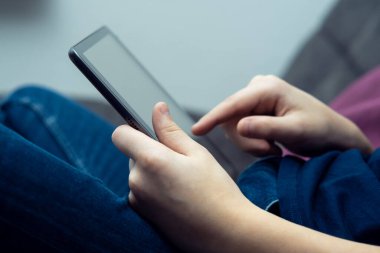 Dijital tablet bilgisayar erkeklerin elinde, yan görüş yakın. Çoklu el bilgisayarı üzerinde çalışan ve yazan genç bir adam. Modern teknoloji, tablet ellerde, dokunmatik ekran, elektronik.