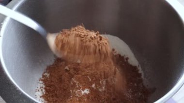 Derin çelik kaseye kuru malzemeler karıştırıyorum. Un için yığınla tatlı kaşığı kakao tozu döküyorum. Geleneksel kek pişirme tarifi, ev yapımı tatlı pişirme süreci, adım adım..