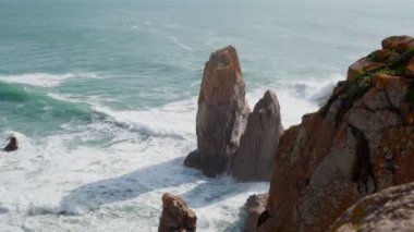 Deniz dalgaları ve deniz kıyısındaki suda kayaları yıkayan köpüklü gelgit videoları. Turkuaz deniz ya da okyanus yüzeyi. Yaz yolculuğu. Sıcak mevsimde, turistik tatil beldesinde dinlenme ve dinlenme. Boşluğu kopyala