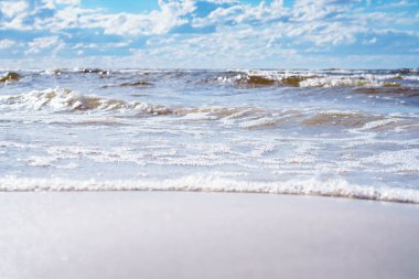 Deniz dalgaları, kumsal dramatik bulutlu gökyüzüne karşı. Doğal durum, suyun gelişi ve turkuaz deniz ya da okyanus yüzeyindeki kırılma dalgaları. Yaz tatili ve yolculuk. Dinlenme ve rahatlama