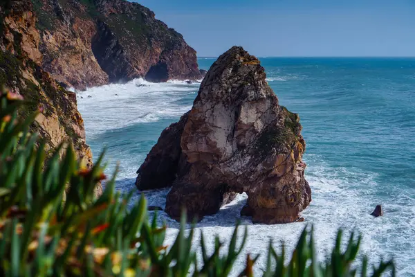 Sahil kıyı şeridi kenarındaki mavi lagün kıyısındaki sarp kayaların yeşil çimlerle kaplı su dağı uçurumlarının manzarası. Yaz, tatil, seyahat, deniz manzarası, turizm, okyanus.