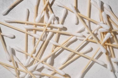 Bir sürü pamuklu çubuk, kulak çubuğu beyaz arka plana saçılmış. Güzellik ve sağlık. Kozmetolojide doğal malzemeler. Yüz bakımı. Düz çizgi. - Model. Kozmetik uzmanı ve makyözlerin aksesuarları..